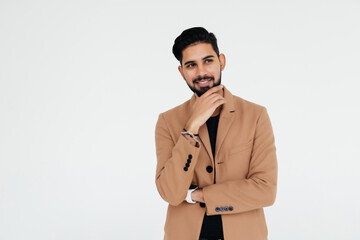 Portrait of handsome young indian man in suit with chin on hand, over white background