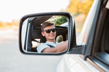 young handsome confident man driving car