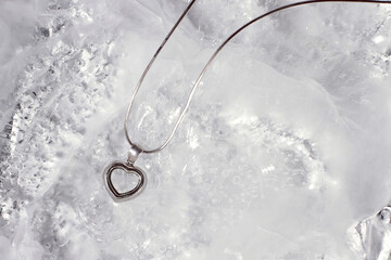 Silver heart jewelry necklace on ice background