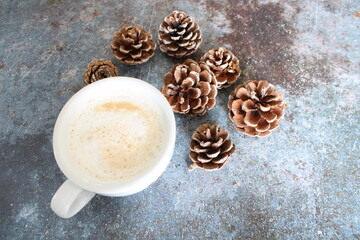 cup of coffee and wintry pine cones on wooden background