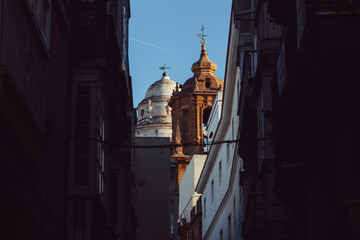 View of the towers of a church in cadiz between the buildings