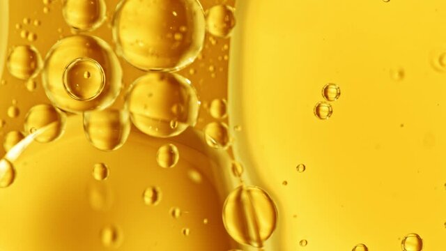 Super Slow Motion Shot of Moving Oil Bubbles on Golden Background at 1000fps.