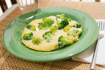 wholesome breakfast. omelet with broccoli on green plate