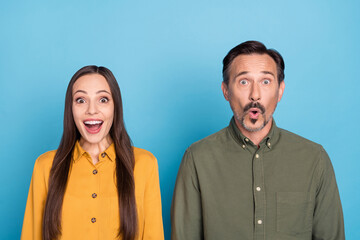 Photo of astonished lady impressed man open mouth unbelievable look camera isolated on blue color background