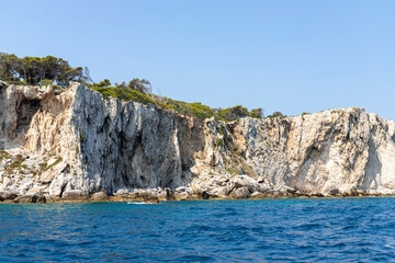 Fototapeta na wymiar Limestone rocks, vegetation and the coast of the island of San Domino of the archipelago of the Tremiti Islands in Puglia, Italy.