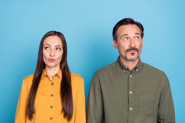 Photo of mature minded married man and woman look empty space idea isolated on pastel blue color background