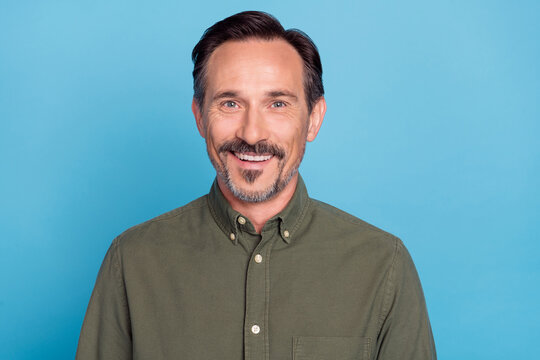 Photo of cheerful glad adult man toothy smile look camera isolated on bright blue color background