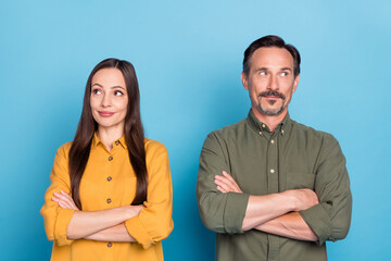 Photo of dreamy confident couple man and woman hold hands crossed look empty space isolated on blue color background