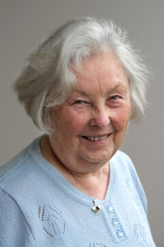 Portrait l&auml;chelnde zufriedene wei&szlig;haarige Seniorin 80plus mit Altersflecken und Rosazea