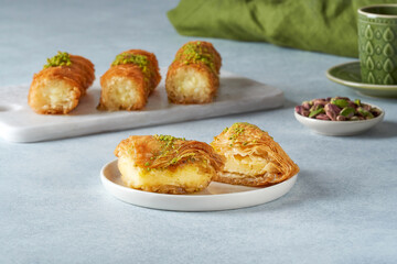 Traditional middle eastern sweets warbat, kunafa with cheeese and pistachio. Closeup, copy space