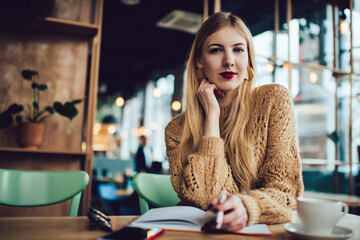 Serious woman with pen in cafe