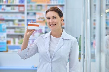 Friendly woman in white coat showing medicine