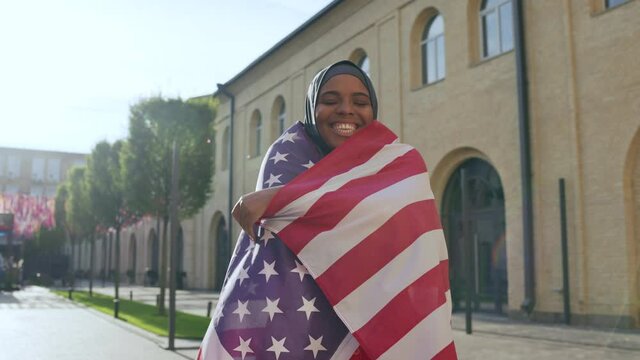 Cheerful black woman with american flag supporting sports team, Independence day