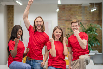 Young people in red tshirts looking joyful and happy