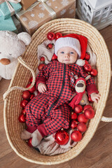 Fototapeta premium Christmas baby boy in santa hat on background of christmas tree with gifts.