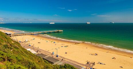 Boscombe beach and pier with cruise liners moored in Poole Bay