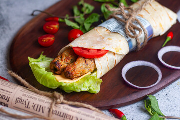 Fresh chicken seekh roll with fresh tomatos, salad, cheese and onions isolated on bright blue...