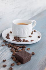 Cup of coffee with grains on gray board