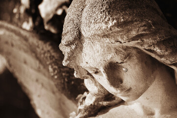 Crying angel. Tears on his face as symbol of death, pain and fear. Fragment of an ancient statue.
