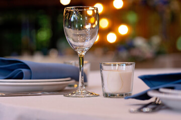 Festive wedding, table setting with blue linen napkins, candles. Wedding decorations. Restaurant menu concept. Soft selective focus.