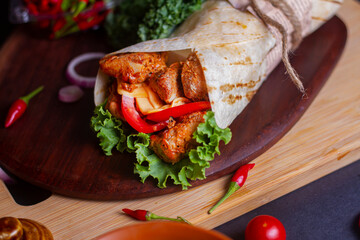 Fresh chicken tikka roll with fresh tomatos, salad, cheese and onions isolated on bright blue...