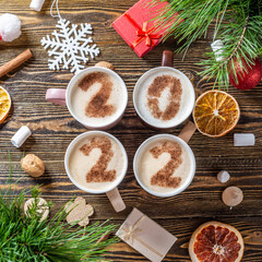 Card with numbers 2022 for New year and Christmas. Cup of coffee with figures on wooden background. Top view. Flat lay
