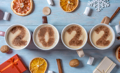 Card with numbers 2022 for New year and Christmas. Cup of coffee with figures on blue wooden background. Top view