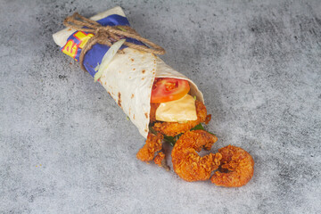 Fresh fried prawns roll with fresh tomatos, salad, cheese and onions isolated on bright blue background. Side view.cope space selective focus