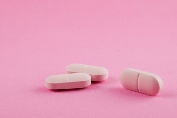Pink pills on pink background. Women health