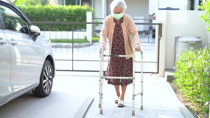 Asian senior or elderly old lady woman patient walk with walker on ramp at home, healthy strong medical concept 