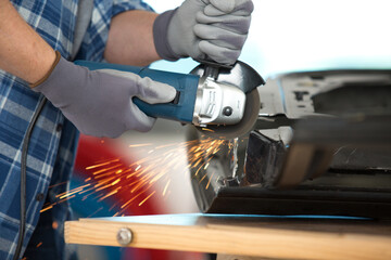 close up of professional blacksmith sawing metal with hand circular