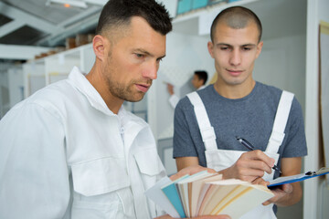 commercial painting apprentice taking notes on color names