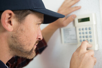 hvac technician fixing a thermostat