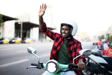 Handsome African man with scooter in the city. Young man riding a scooter.