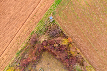 View straight down on harvested fields in autumn and a raised hide 