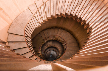 Top view of a rusting metal spiral staircase, beautifully curled towards the bottom