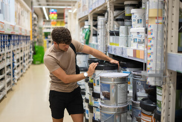 Male customer examining bucket of paint