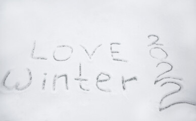 snowy surface with the inscription love winter 2022. Christmas Eve walks, fun, winter holidays. snow games