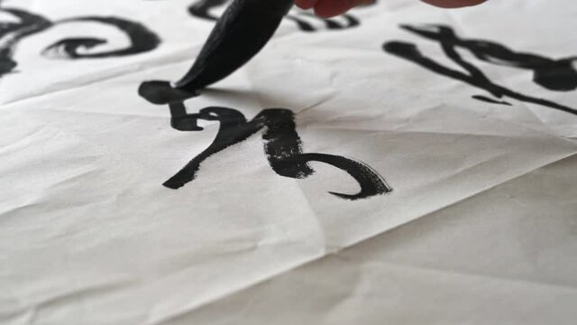 An old calligrapher is writing calligraphy and writing calligraphy