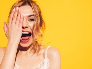 Fashion beauty portrait of young brunette woman with natural stylish  makeup and perfect clean skin. Sexy model with long curly hair posing in studio on yellow background. Screaming and shouting