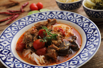 Local northern thai food Rice noodles with pork in spicy soup in wood background