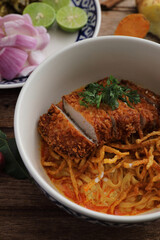 Local northern Thai food Egg noodle curry with fried pork on wood background