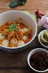 Local northern Thai food Egg noodle curry with meatballs on wood background