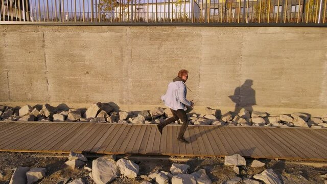 Man dancing footfork on the background of a concrete wall. Horizontal harness on a quadcopter. Autumn outdoor dancing