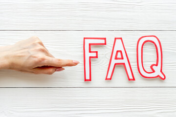 Hands with faq - frequently asked questions - made of paper