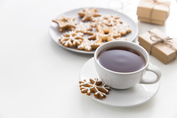 Cup of coffee with gingerbread christmas cookies in the form of stars on a white table. Copy space