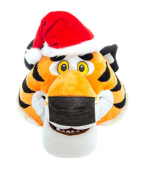 Toy tiger head in red santa claus hat and black protective medical mask, isolate. Concept for new year and birth 2022 during the coronavirus epidemic, close-up