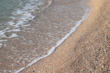 Beautiful seascape with beautiful sea waves and sea foam on shore with sea water on beach by sea