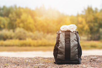 Matching backpack with fat rope on the sunshine of the forest. Hiking equipment.