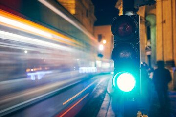 Green on traffic light against light trails of tram and cars. Night scene of city street in Prague, Czech Republic. .